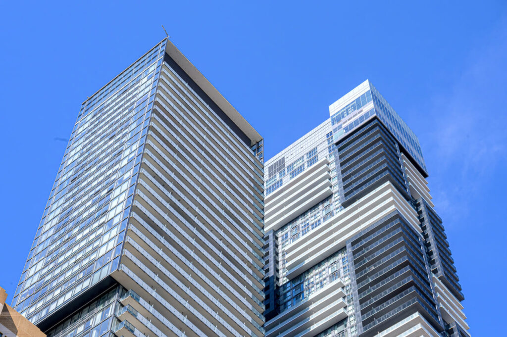 Foto tirada de dois prédios com o céu azul.