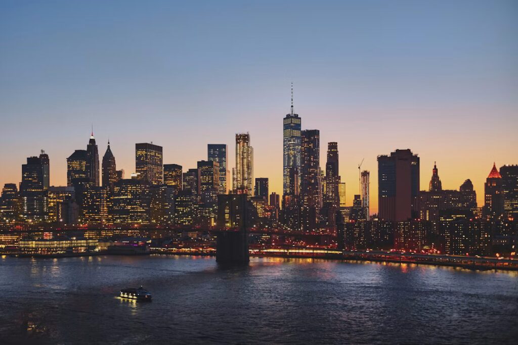 Skyline de uma grande cidade ao entardecer com prédios iluminados, ilustrando a consultoria para incorporadoras